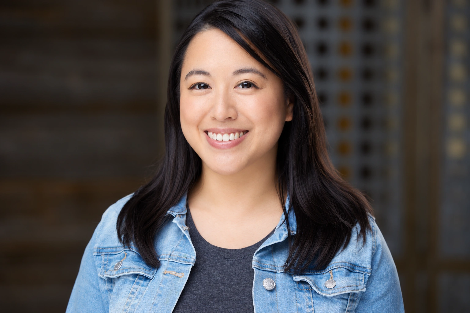 Tiffany Iris — Smiling headshot in a denim jacket